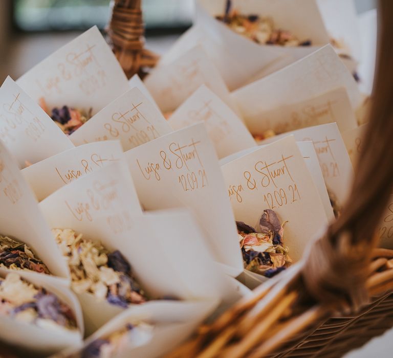 Confetti cones with dried confetti in woven wooden basket at wedding in Buckinghamshire