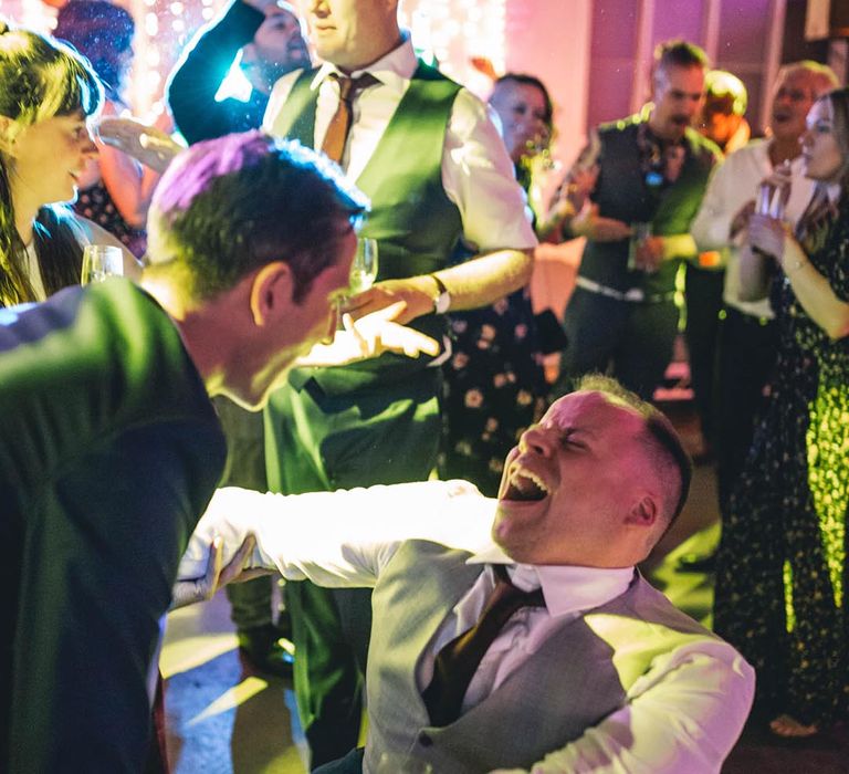 Groom in wheelchair dances with wedding guests