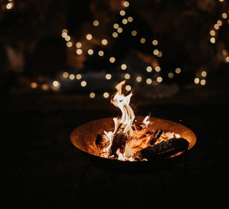 Romantic boho campfire proposal with fire pit and fairy lights 