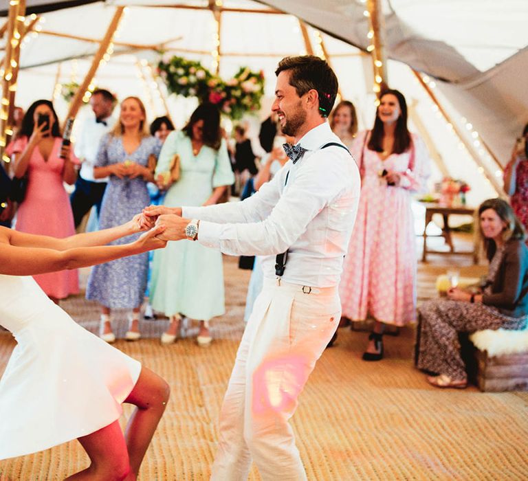 Bride & groom dance as bride wears short dress during reception