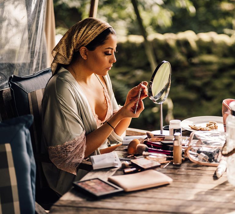 Bride does her makeup on the morning of her wedding day