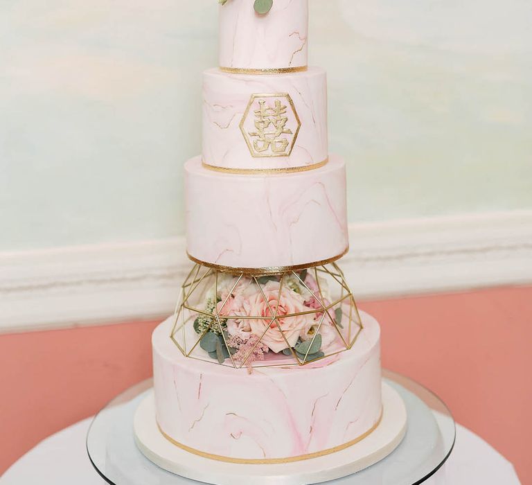 4-tier marble wedding cake complete with blush pink frosting and gold detailing 