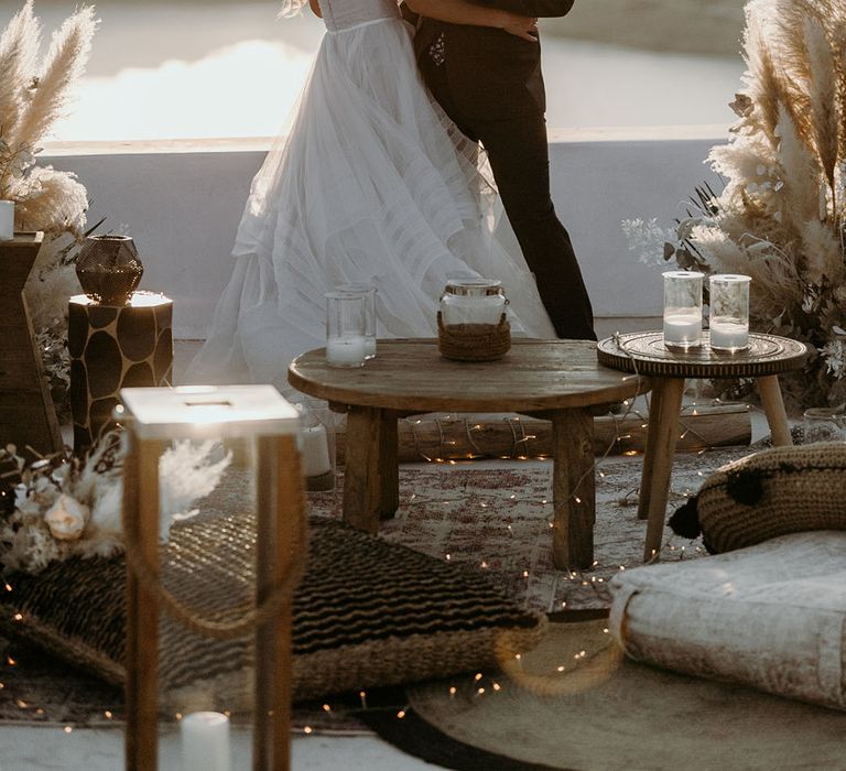 Bride & groom embrace outdoors as they hold champagne on their wedding day