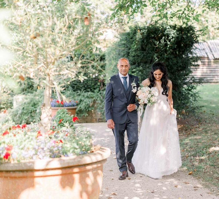 Bride & her father walk together to the aisle on her wedding day