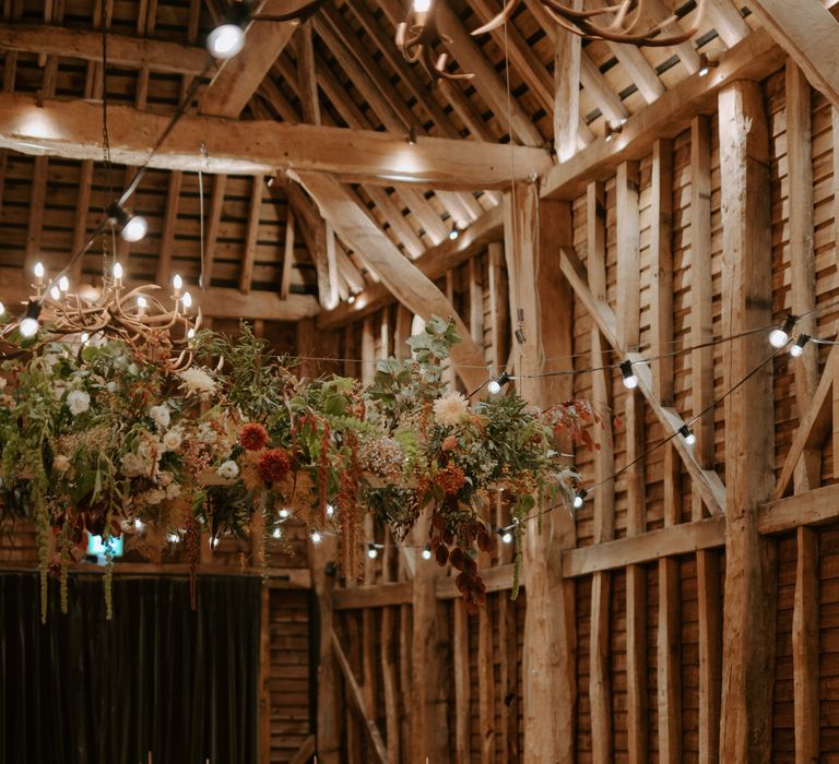 Festoon lighting and flower decor at barn venue