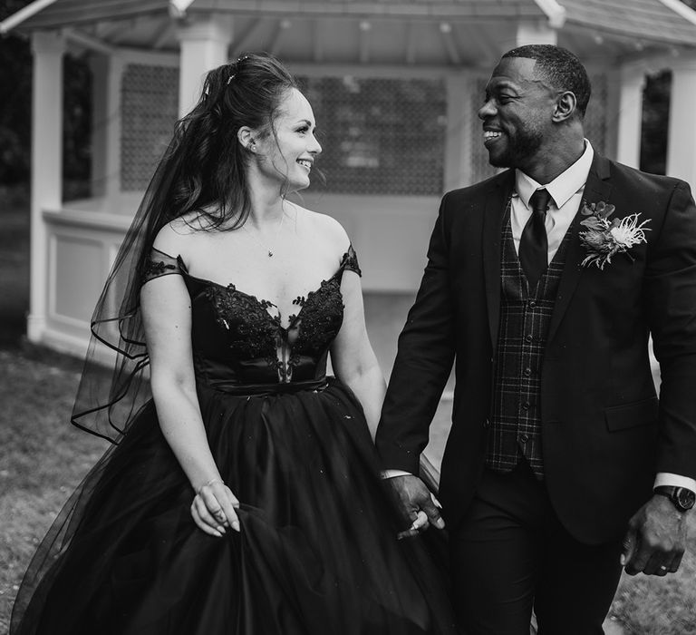 Bride & groom walk hand in hand after wedding ceremony 