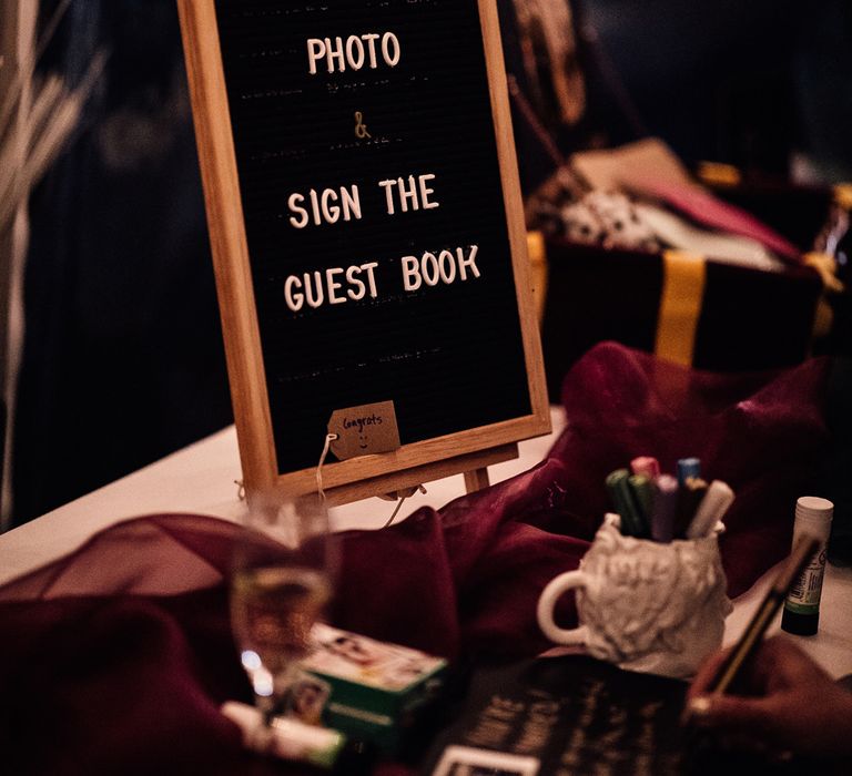 Polaroid guest book wedding sign on table at autumn wedding reception