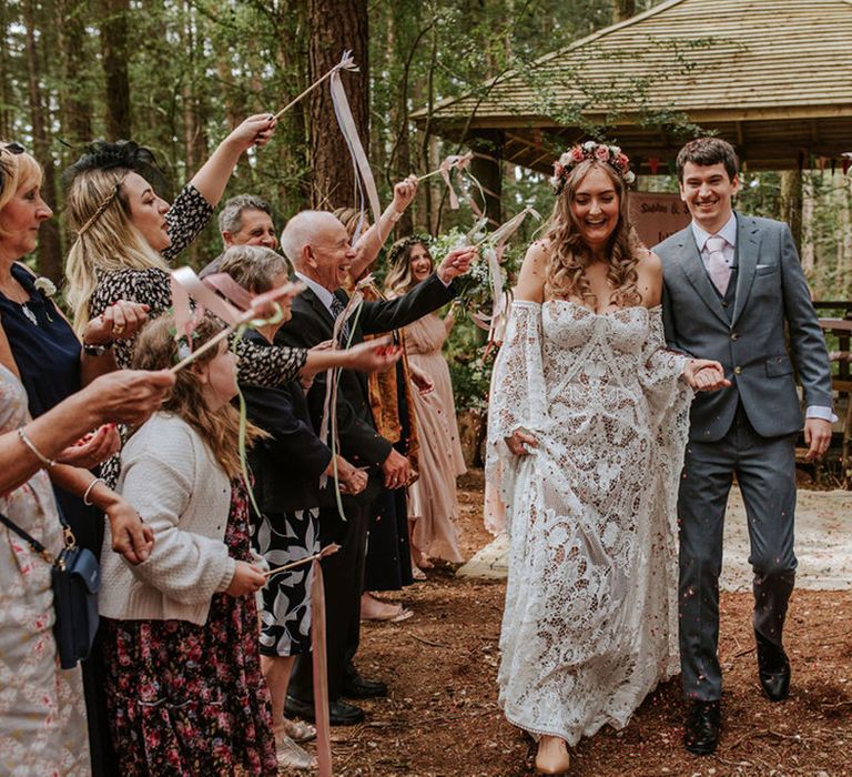 Wedding guests wave ribbon wands to celebrate the marriage of bride and groom at fantasy wedding 