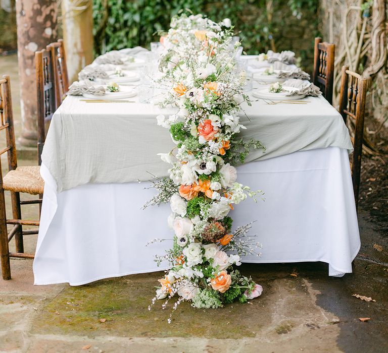 outdoor wedding reception table with peach and white flower table centrepiece runner 