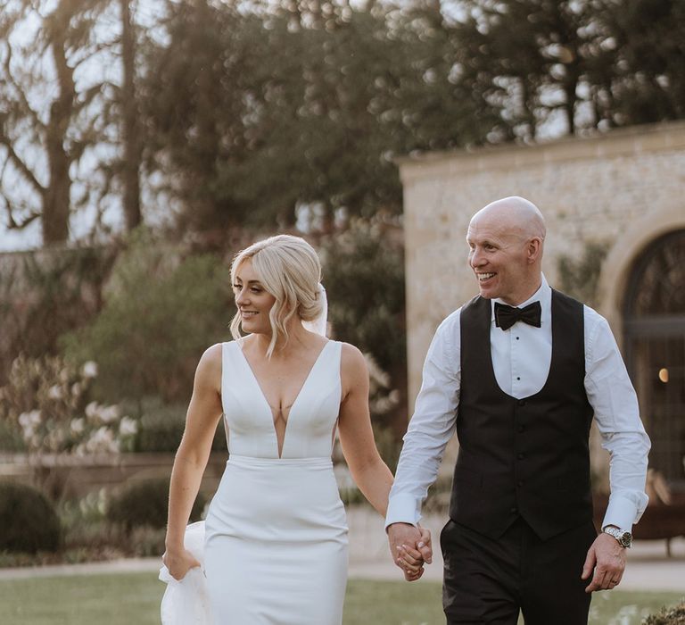 Bride and groom walk hand in hand around Middleton Lodge wedding venue 