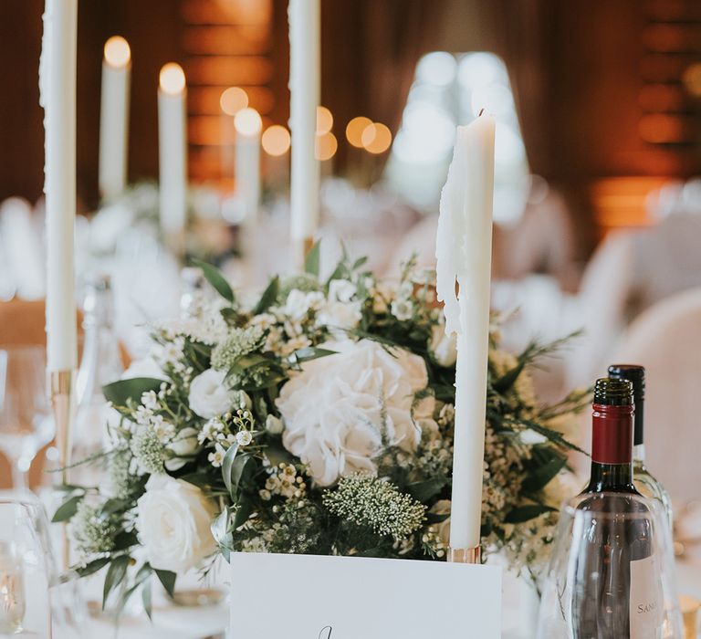 White candles and white rose wedding centrepiece table setting 