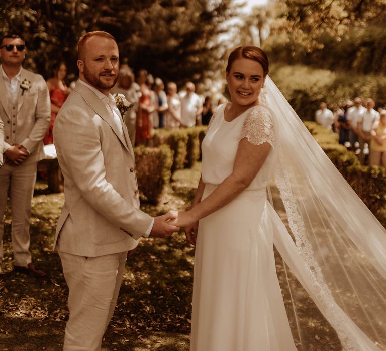 Bride & groom during outdoor ceremony in Spain surrounded by trees for relaxed and intimate wedding day