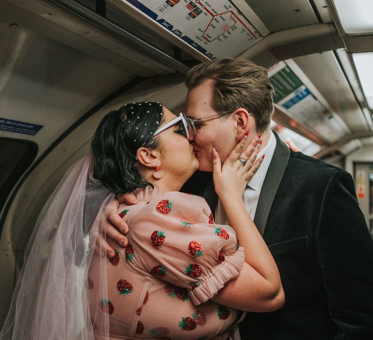 Bride wears pearl hair accessories and kisses her groom on the tube after wedding ceremony 