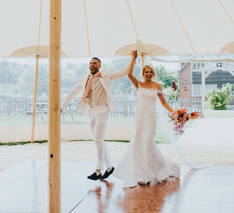 Bride and groom enter their wedding marquee reception with disco ball decor 