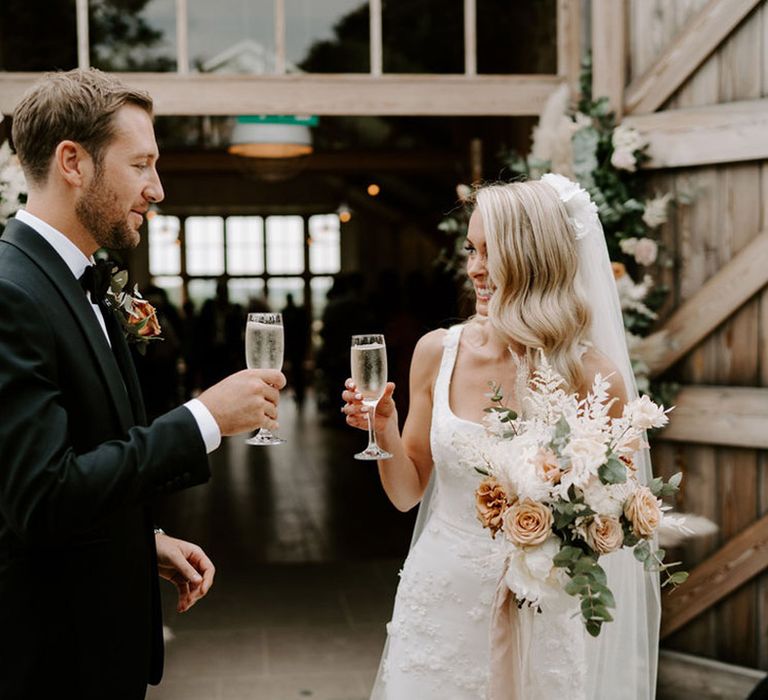 Bride and groom share a glass of champagne after their wedding ceremony 