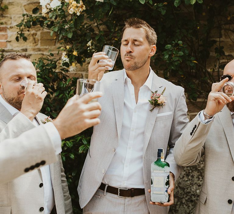 Groom takes some shots with his groomsmen before the wedding 