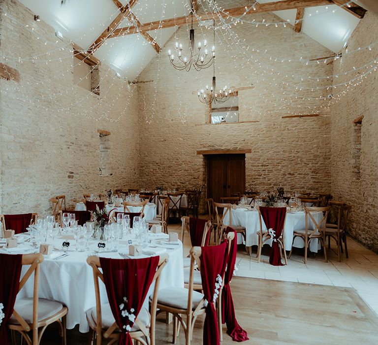 Round tables with fairy lights decorating the Kingscote Barn rustic wedding venue 