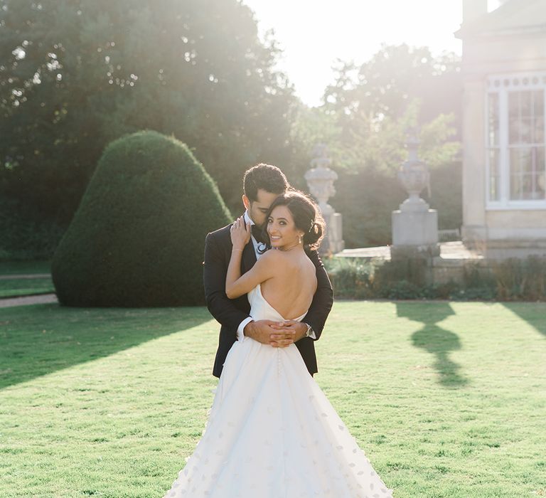 Bride wears Emma Beaumont design wedding dress with V-shaped back and floral appliqué Princess skirt  