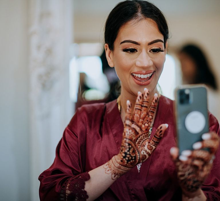 Bride showing off bridal makeup and bridal henna on video call