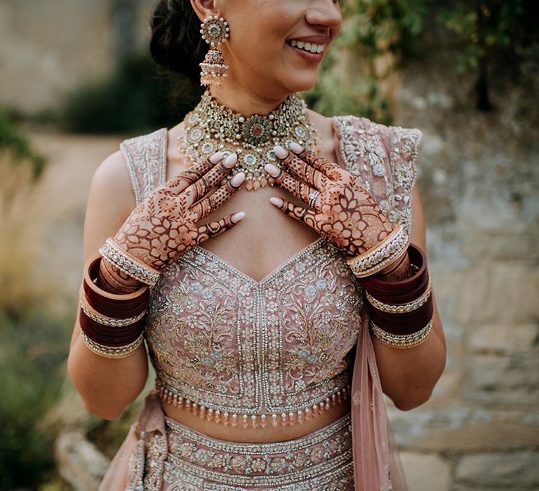 Close up of Panjabi Bride's beautiful Indian wedding henna, Indian wedding jewellery and a golden bridal Lehnga