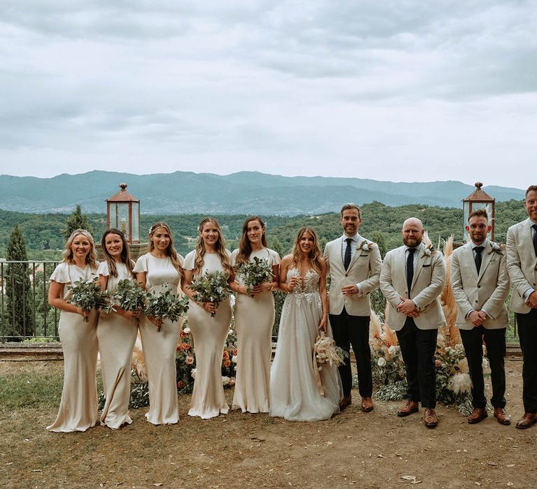 I do crew in off-white bridesmaid dresses and linen suits with bride and groom at destination wedding