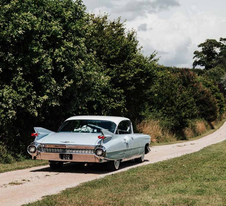 Baby blue classic wedding car driving to Brickhouse Vineyard Devon wedding venue 