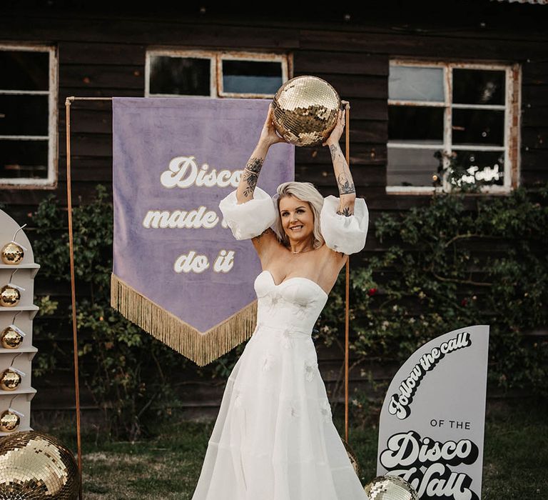 Purple retro fringe wedding banner with gold disco balls with bride in strapless wedding dress with detachable sleeves 