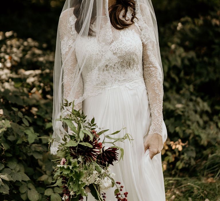 Bride in delicate lace long sleeve wedding with embroidered edge veil 