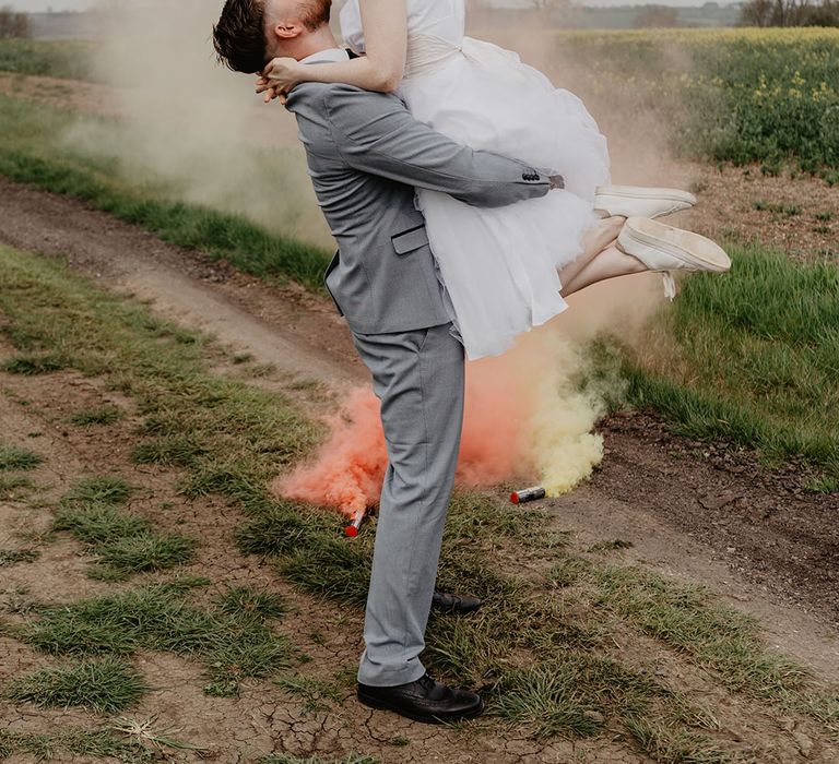 The groom lifts the bride for a picture at the outdoor wedding venue, Hardwick Moat Weddings 