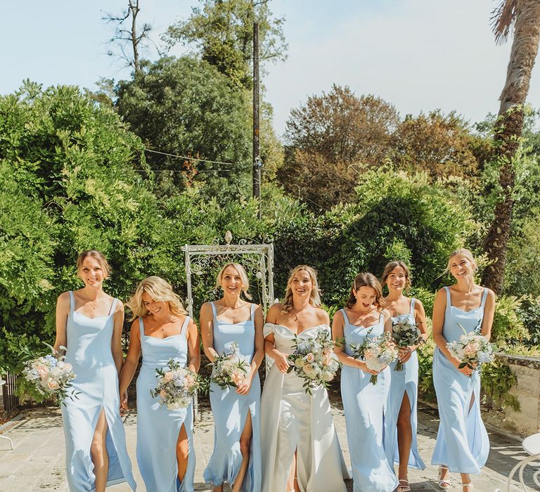 Bridesmaids wearing powder blue bridesmaid dresses with the bride in an off the shoulder wedding dress 