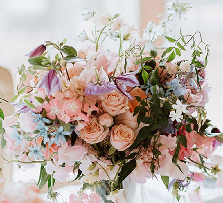 White, pink, purple and blue pastel wedding table flowers created by our Recommended Supplier 