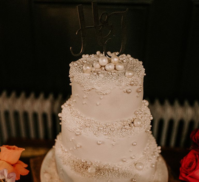 Three tier white iced pearl wedding cake with black personalised cake topper 