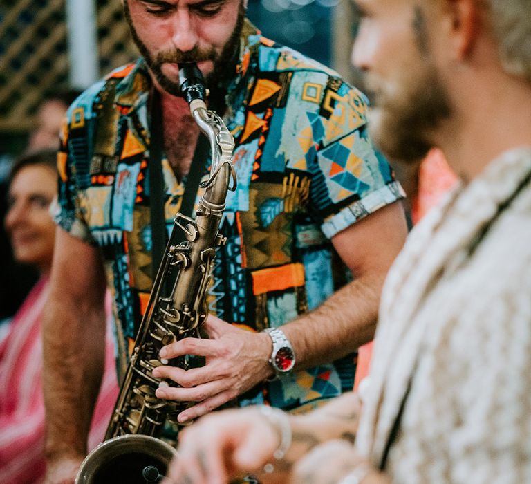 Saxophonist and brass band plays live music at the wedding reception 