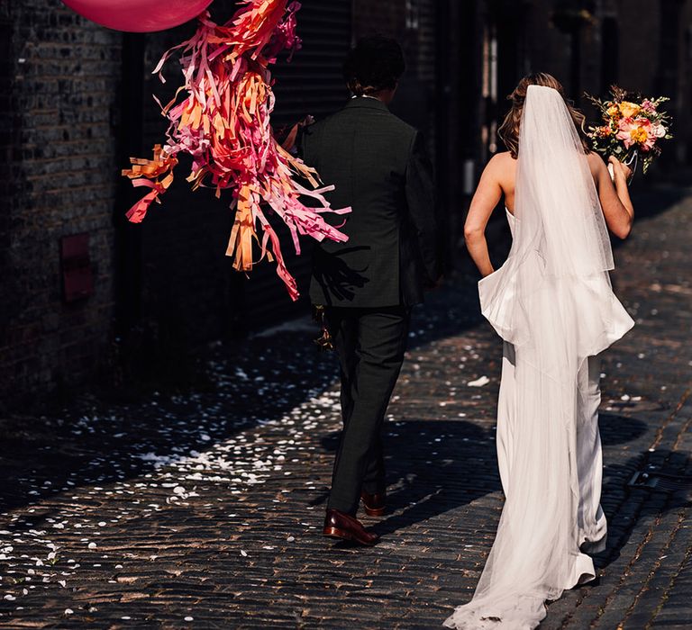 Pink wedding balloon decorations with streamers at city wedding 