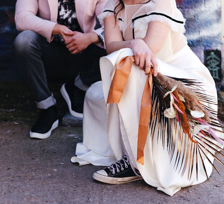 Bride in romantic wedding dress, bridal headband and trainers 