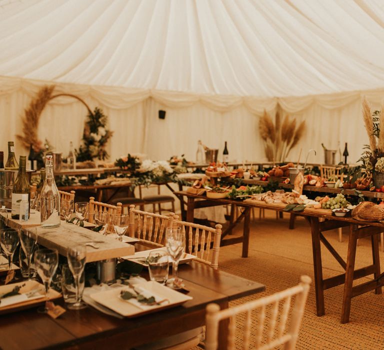 Intimate home marquee reception with hoop decor, foliage and dried grasses. 