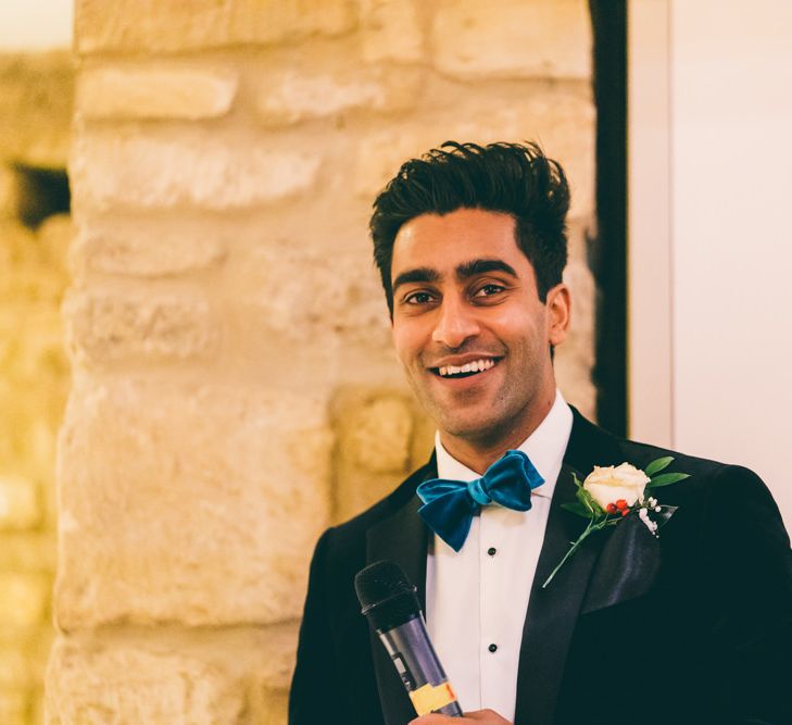 Groom in teal bow tie giving his wedding speech