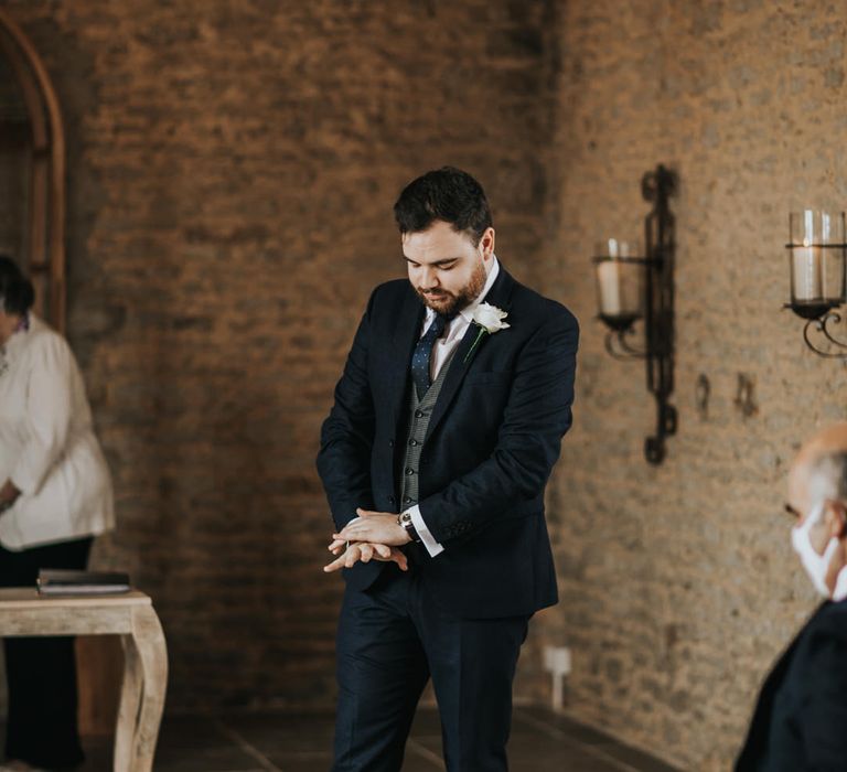 Groom in navy three piece suit with brown shoes