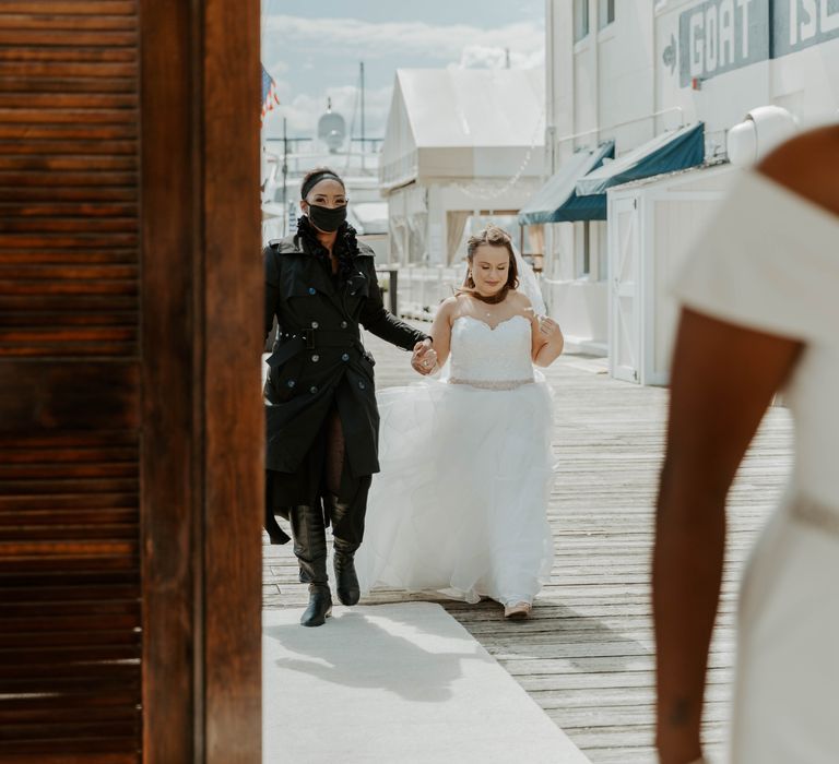 Same sex wedding first look with bride in strapless wedding dress approaching her bride in a jumpsuit