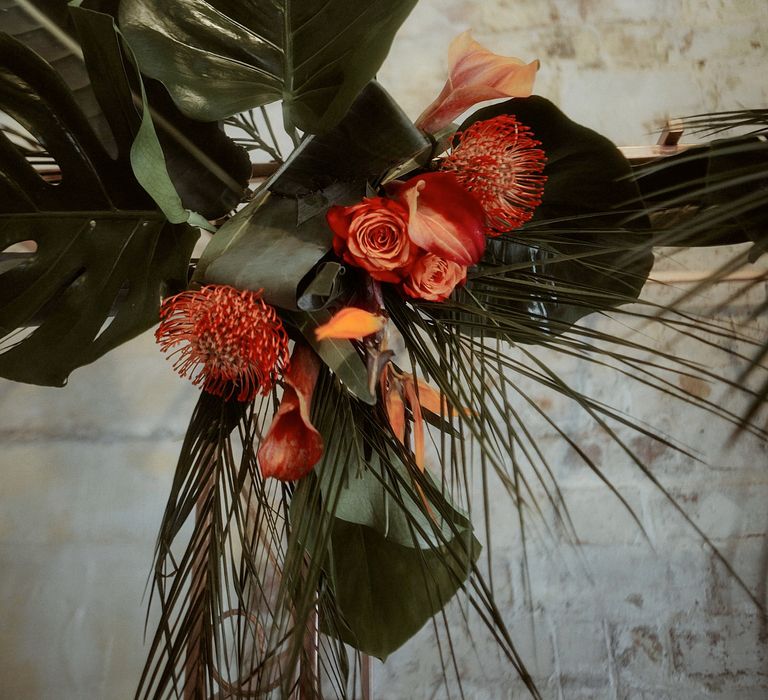 Topical wedding flower decor with bird of paradise, lilies, and fern leaves 