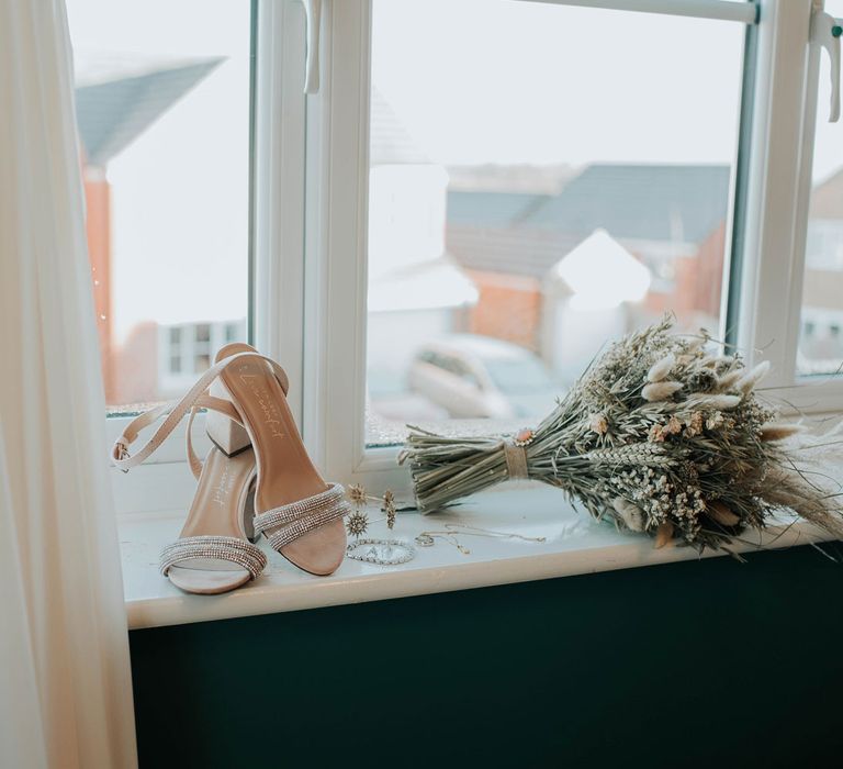 Silver strap open toe heels and artisan dried flower bouquet on windowsill