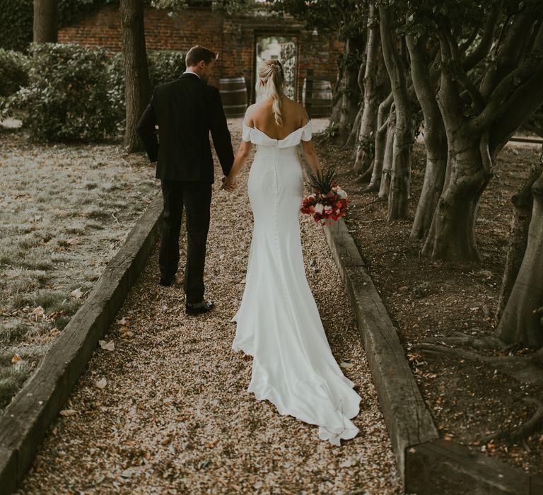 Bride & groom walk through countryside 