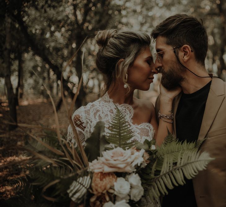 Intimate elopement wedding photography with bride in a lace wedding dress embracing her grooms face