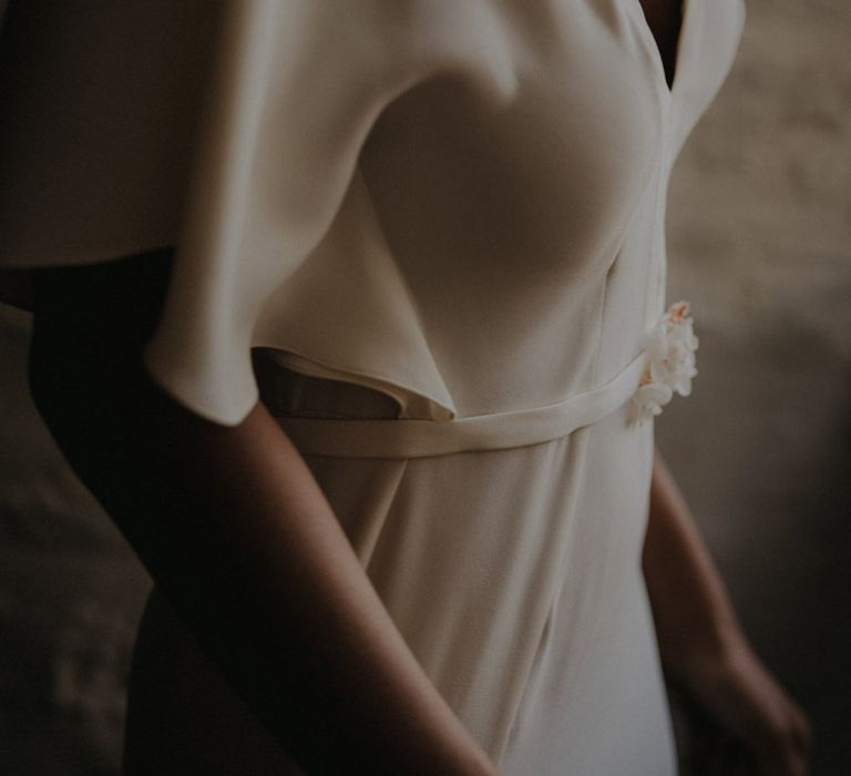 minimalist wedding dress in fluid crepe with plunging neckline and belt detail