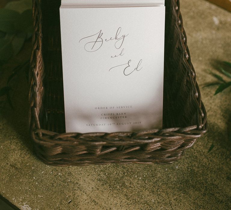 A basket of minimal calligraphy wedding order of service booklets photographed by Scuffins and Scuffins