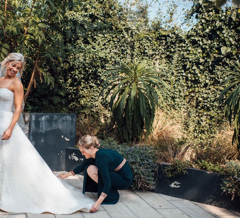 Bride has her train adjusted on the day of her wedding