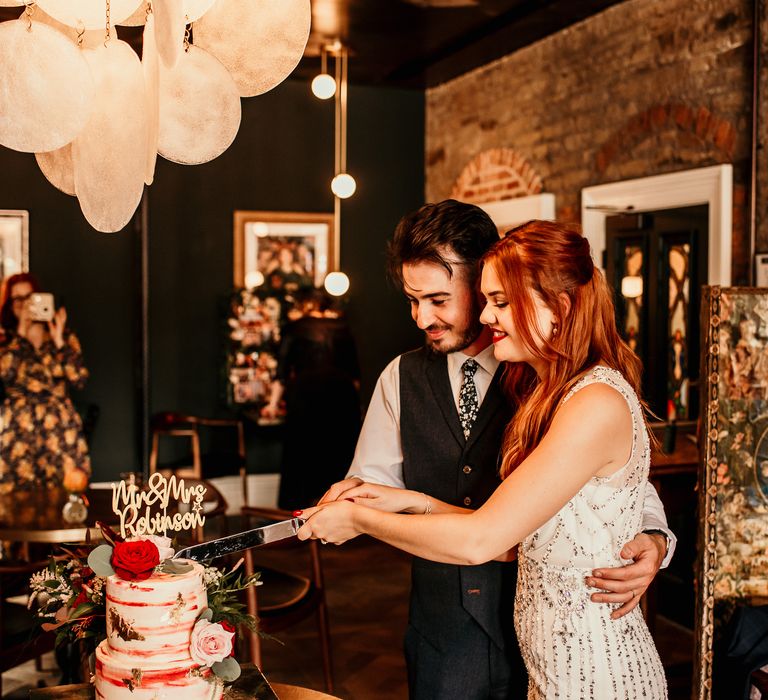 Bride & groom cut their wedding cake during intimate reception