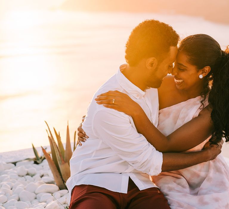 Bride & groom embrace and laugh together on their honeymoon