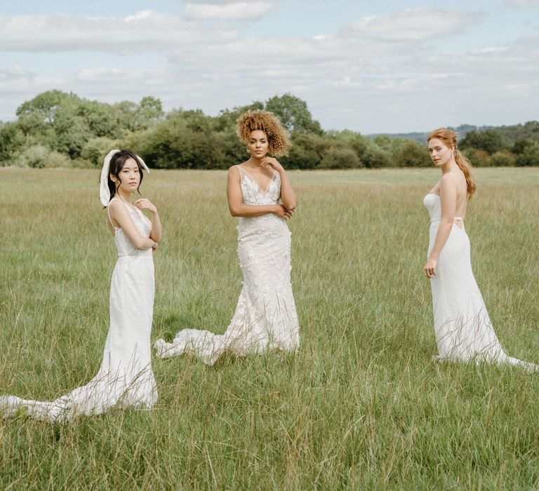 Three brides in the fields at Berwick Lodge wearing boho inspired wedding dresses from Made With Love and Emmy Mae Bridal