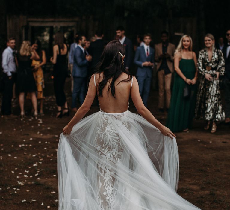 Bride entering wedding reception carrying her tulle skirt